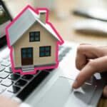 hands on a laptop with a house on top